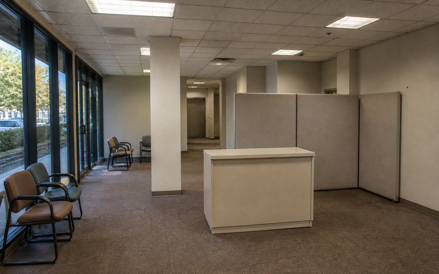 Commercial Remodeling before planning visualization of the same space: A cramped dated lobby with opaque partitions and a desk in the path reveals circulation, lighting, accessibility, ceiling, and finish constraints.