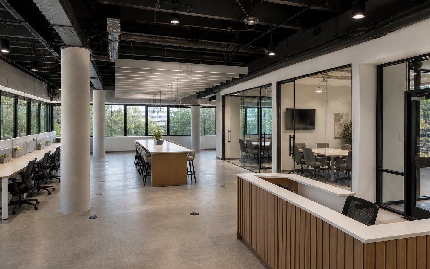 Office Remodeling after planning visualization of the same space: The finished workplace keeps that exact room, workstation, table, reception, column, aisle, and ceiling-baffle geometry.