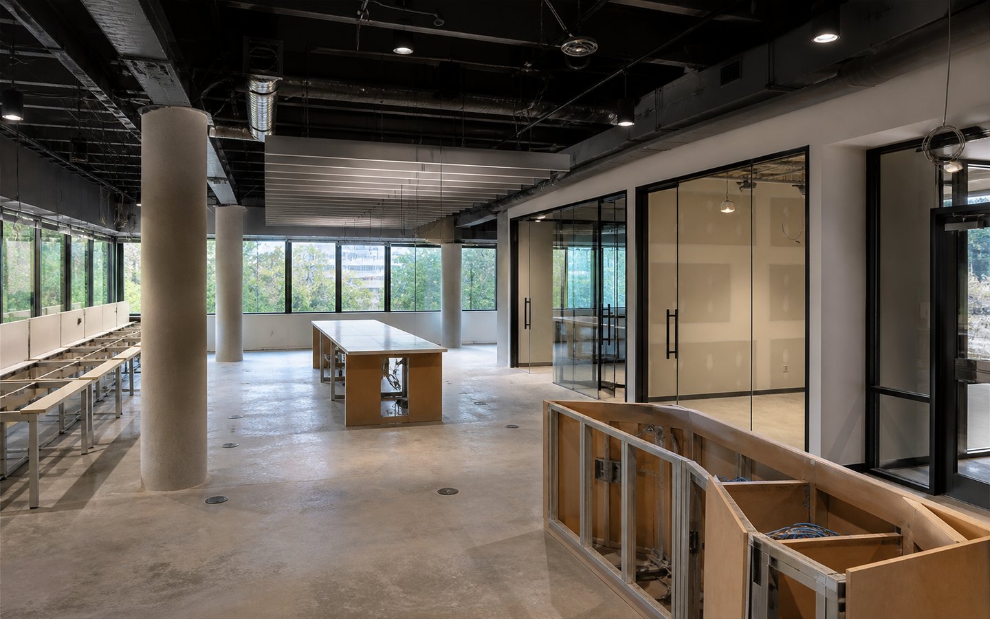 Office Remodeling during planning visualization of the same space: The two glass rooms, bench workstations, collaboration table, reception, baffles, and floor boxes establish the redesigned office plan.