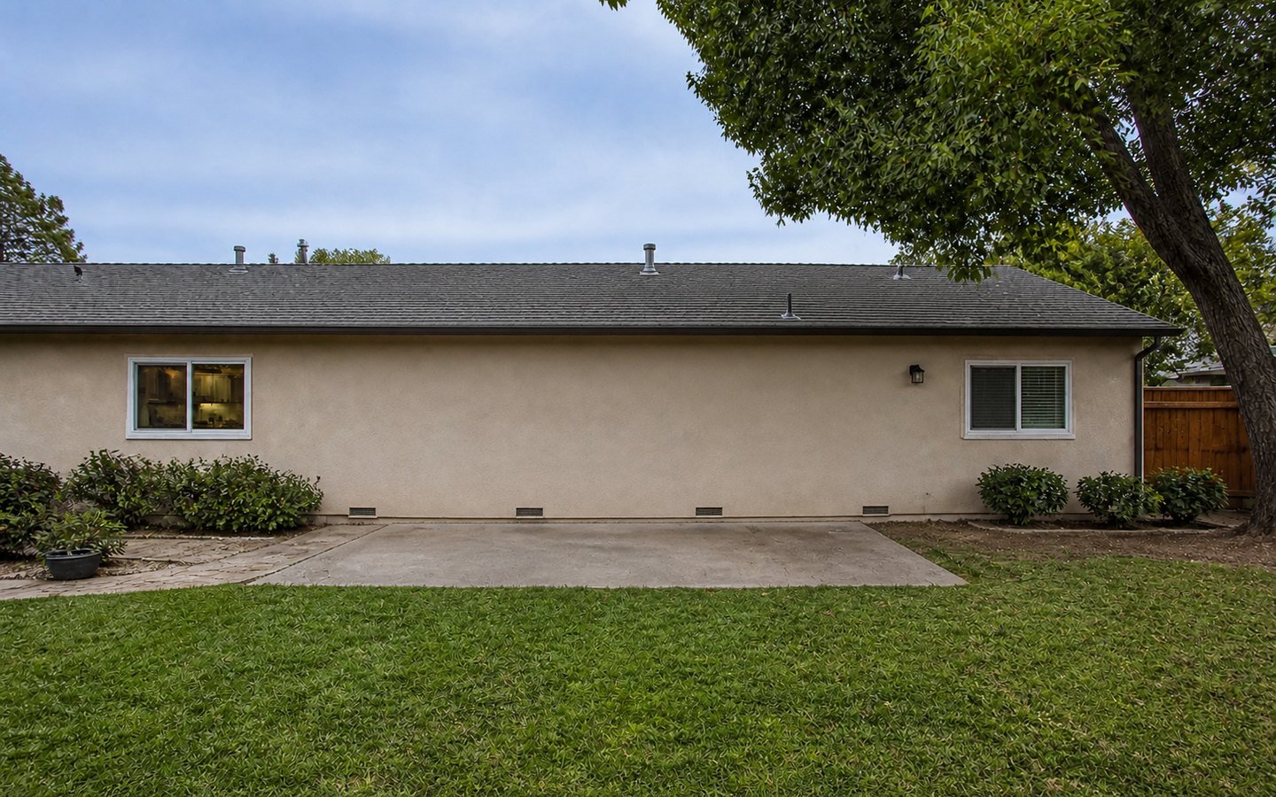 Room Additions before planning visualization of the same space: The original flat rear wall and small patio show the site, access, tie-in, daylight, and roofline questions.